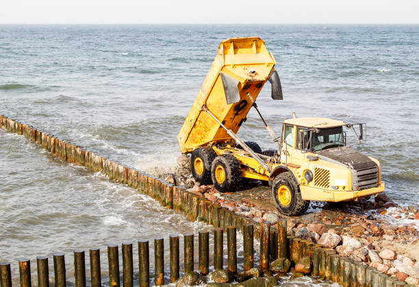 istock heavy truck during the construction of a breakwater 1295654483