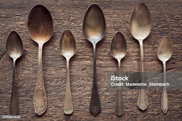 Seven Empty Alpacca Vintage Spoons On A Wooden Rustic Background Stock Photo - Download Image Now