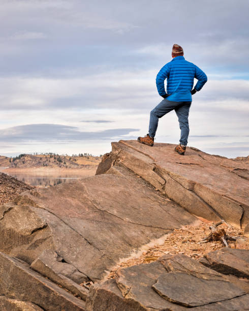 ロッキー山脈のふもとにある岩の崖の上の男性ハイカー - fort collins rock cliff mountain range ストックフォトと画像