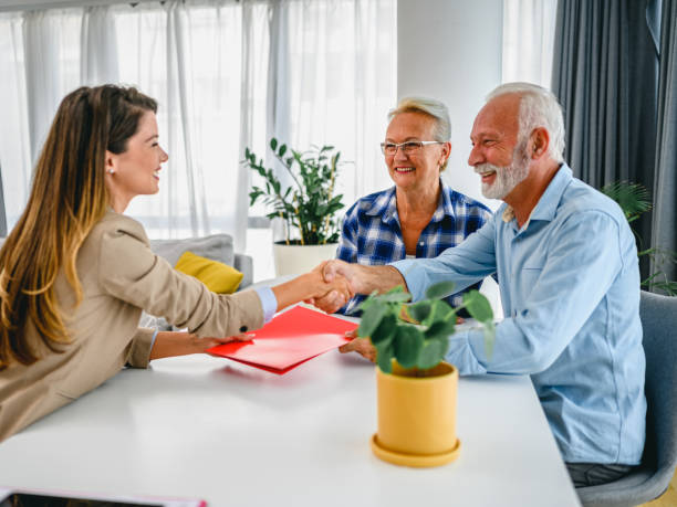 istock Senior couple shaking hands with financial advisor 1295654700