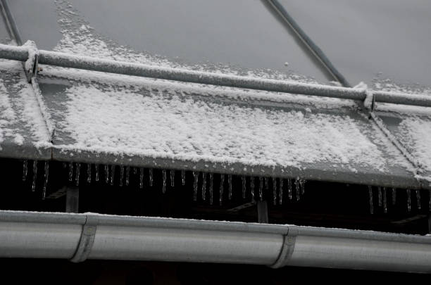 verzinktes metalldach in den bergen mit einer stange gegen das schnelle abrutschen von schnee. wenn schnee und eis schnell auf menschen unter dem dach fallen, werden sie verletzt oder tot sein. verlangsamt die lawine - icicle hanging snow moving down stock-fotos und bilder