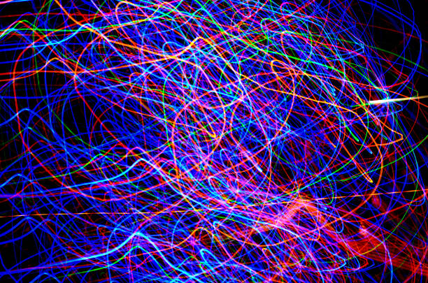istock Abstract tangled lines on a black background represent the movements of electrons in their cosmic orbits. Christmas tree lights in different graphic concept. 1295655642