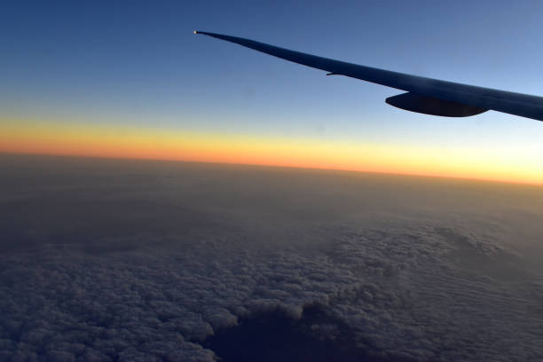 istock Silhouette of Airplan wing in twilight sky, with beautiful light from dramatic sunset, Romantic view from airplane window. 1295656904