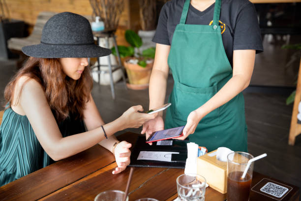 istock Lady customer holding phone near nfc terminal make contactless mobile paymen. 1295659021