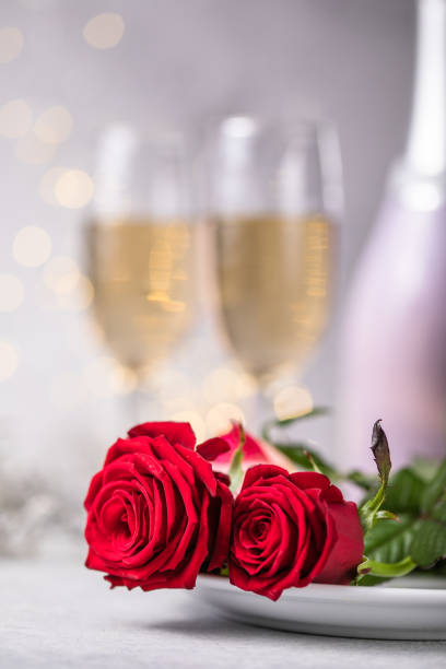 istock Valentines day table setting  red roses and champagne glasses on concrete background. Valentine 's greeting card - Image 1295659579