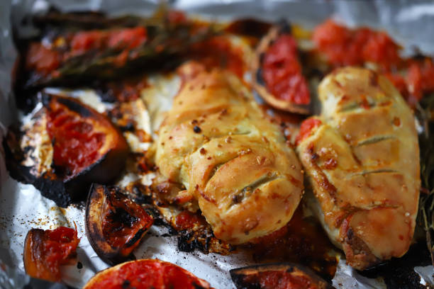 istock Baked chicken fillet with grapefruit and rosemary on a baking sheet. 1295660439