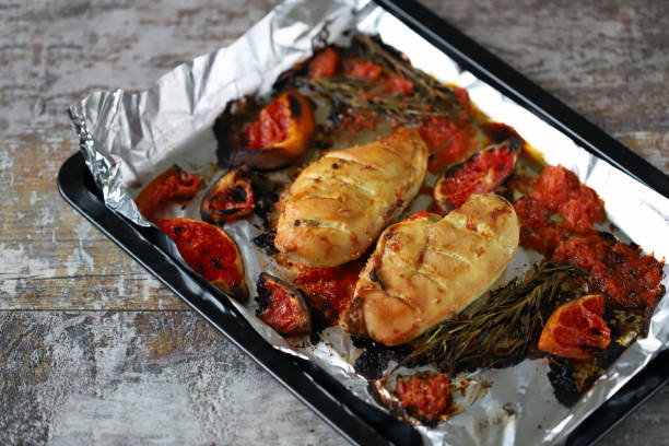 istock Baked chicken fillet with grapefruit and rosemary on a baking sheet. 1295660445