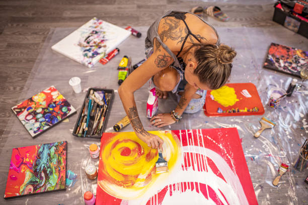 istock Pretty talented female painter painting while sitting on the floor 1295661864