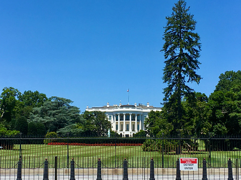 White House in Washington DC with fence and „restricted area“ sign