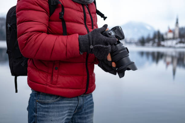 istock Photographer checking camera settings outdoors. 1295664339