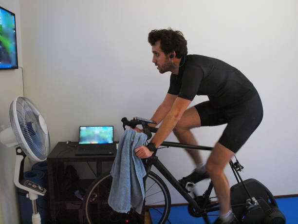 joven en bicicleta de ejercicio en casa - alenka fotografías e imágenes de stock