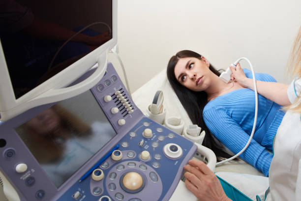 istock Doctor using ultrasound scanning machine examining female neck 1295668336