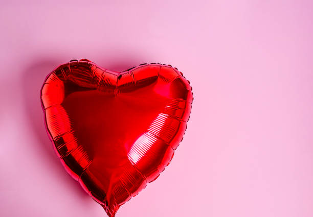 istock Red heart balloon on a pink background. 1295672698