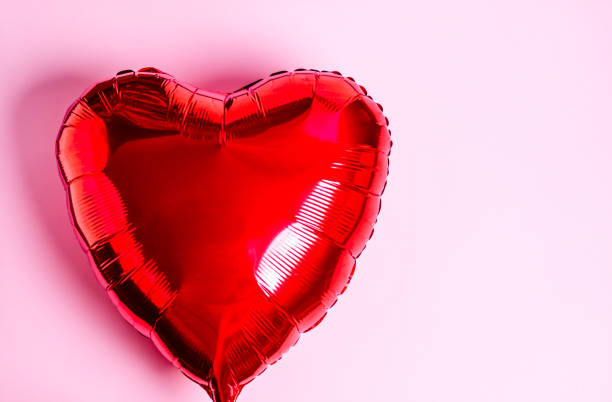 istock Red heart balloon on a pink background. 1295672712