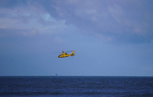 istock a yellow helicopter above water 1295672933