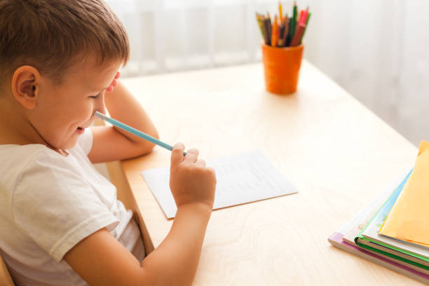 istock cute little boy studing at home. 1295675245
