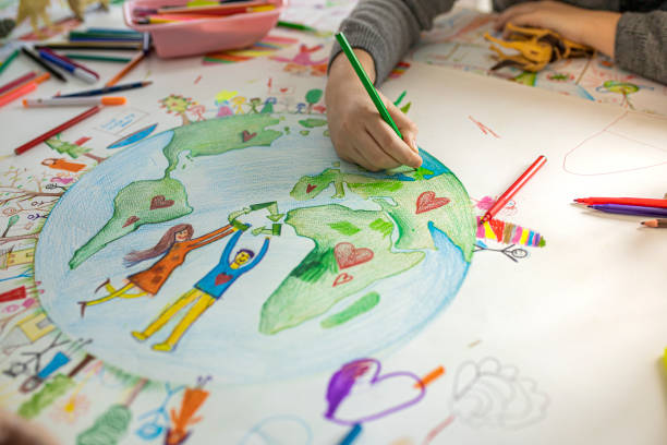Creative kids drawing on paper Close up of child's hands while drawing Ecofriendly theme on paper. pencil art cartoons stock pictures, royalty-free photos & images
