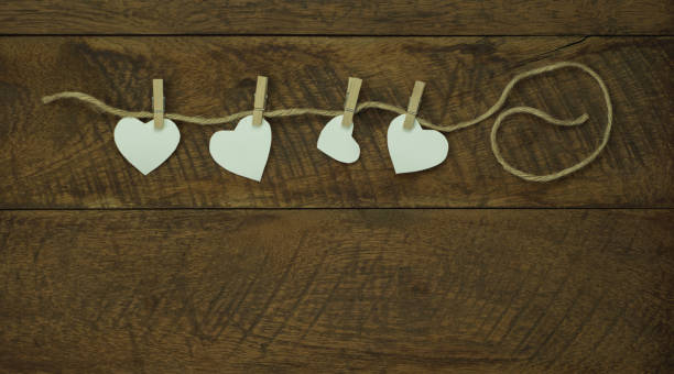 Table top view aerial image of valentine 's day background concept.Love text hang on rope clotheslines.Flat lay on modern rustic wooden.pastel tone.Items create by handmade sign for the season. imagen aérea de la vista superior de la tabla del concepto de fondo del día de san valentín. texto de amor colgar en los tendederos de la cuerda. plano yacía en el moderno tono rústico de madera.pastel. artículos creados por cartel hecho a mano para
