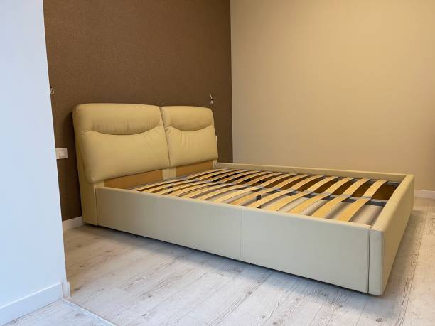 istock white bed without mattress in an empty room 1295678896
