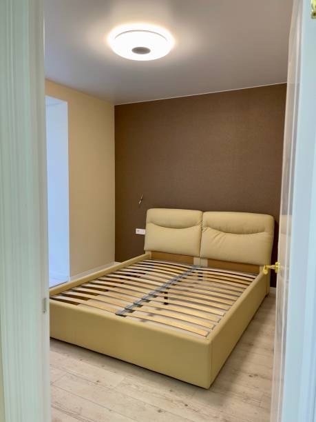 istock white bed without mattress in an empty room 1295678902