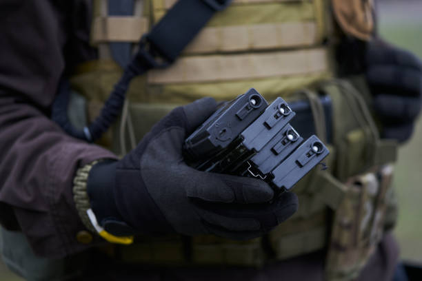 airsoft player segura revistas para uma metralhadora na mão - conciliator - fotografias e filmes do acervo