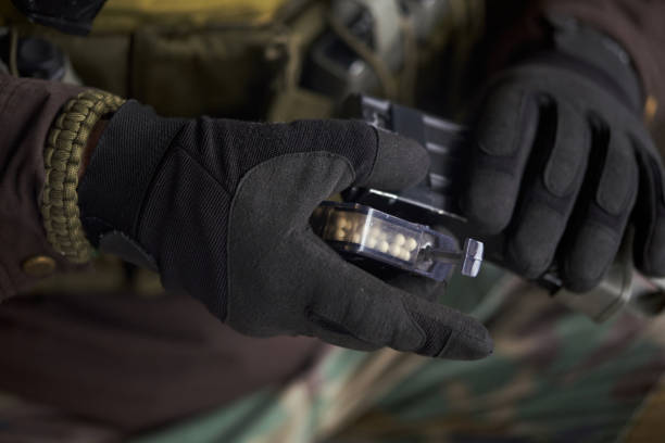 istock Airsoft player charges balls into machine gun magazine 1295679056