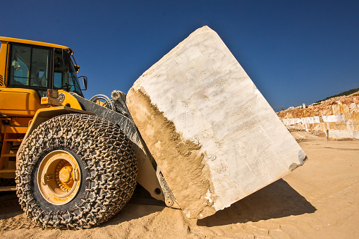 Wheel loader (Bulldozer) carrying marble block in a marble quarry