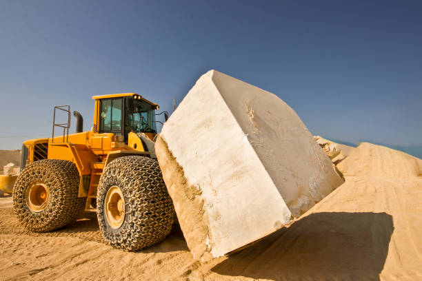 istock Bulldozer carrying oversized marble block in quarry 1295685042