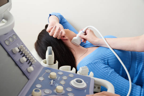 istock Doctor using ultrasound scanning machine examining female neck 1295685133