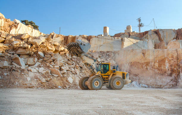 istock Bulldozer working in a quarry and carrying marble stones 1295685315