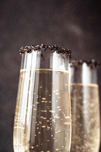 Flutes of champagne with black caviar rim