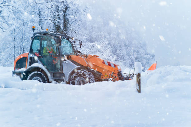 caricatore anteriore rimuove tonnellate di neve da una strada di campagna in forti nevicate - snow cleaning foto e immagini stock