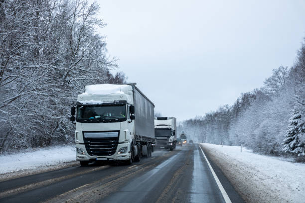 istock Trucks on a country road after a snowfall 1295687989