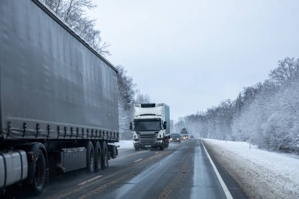 istock Trucks on a country road after a snowfall 1295688153