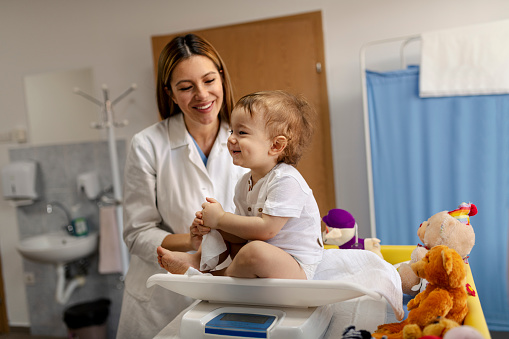 Pediatra jugando con niño en la mesa en el consultorio médico photo
