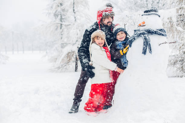istock Dad With Children Playing In Snow 1295688606