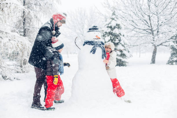 istock Dad With Children Playing In Snow 1295689557