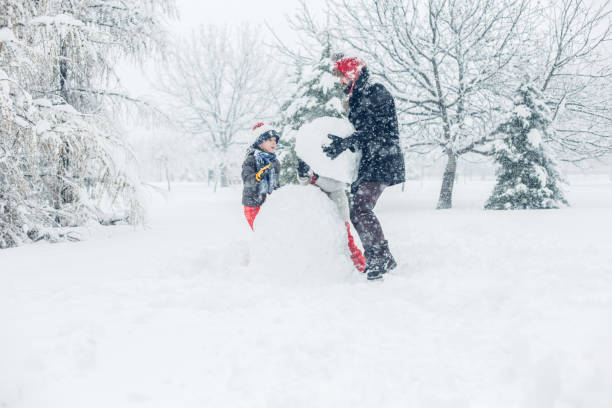 istock Dad With Children Playing In Snow 1295690319