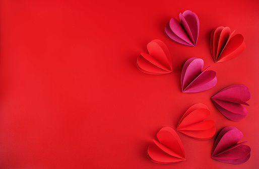 Red background with red and pink pepper hearts for Valentine's day. toning. selective focus