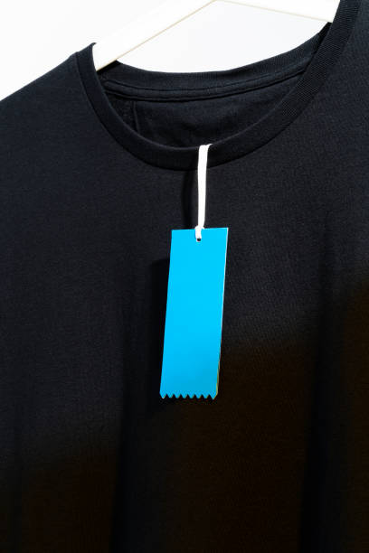 istock White t-shirt with blank blue price tag, displayed on white hanger 1295691361