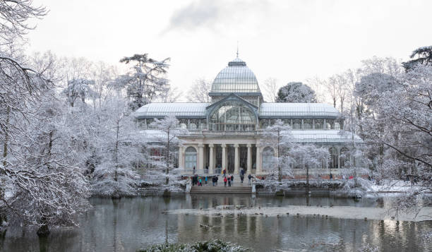 crystal palace (palacio de cristal) mit schnee bedeckt in retiro park (parque del retiro) wegen der großen schneefall durch den filomena sturm verursacht - snow park road cold stock-fotos und bilder