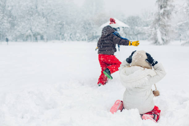 istock Boy And Girl Playing In Snow 1295692771