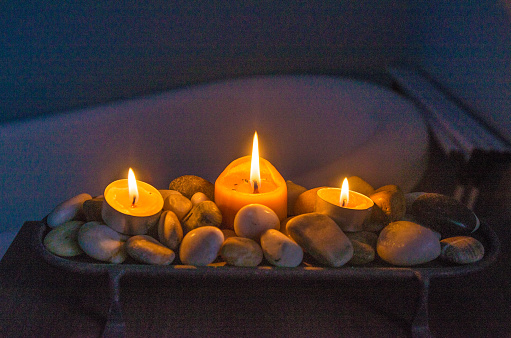 Tray filled with stones and candles in bathroom