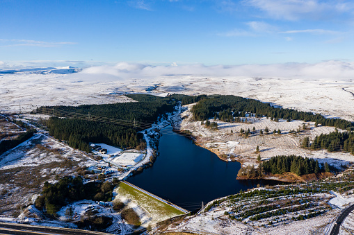 Aerial view of a cold, snow covered winter town with semi frozen lakes and ponds (Ebbw Vale)