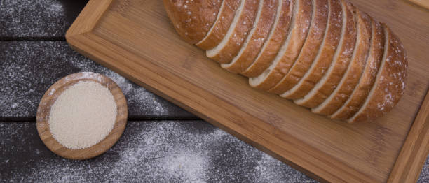 bakery - sliced golden rustic crispy loaves of bread and buns on black chalkboard background top view - baked bread breakfast brown imagens e fotografias de stock