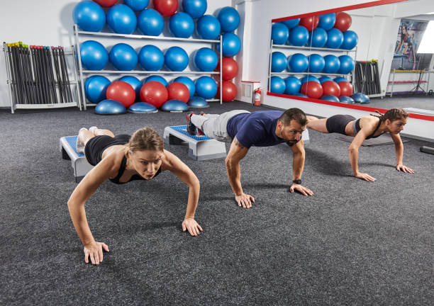 istock Fitness trainer and girls doing pushups 1295699512