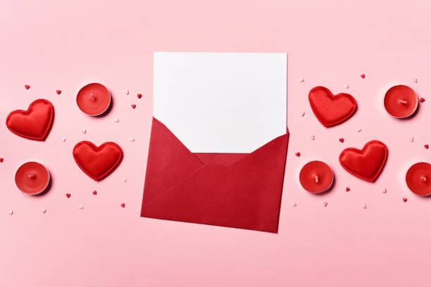 istock Romantic concept. Valentines day background. Red envelope with blank letter and hearts on pink background 1295701442