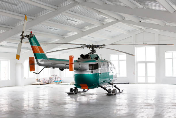 istock Green and silver helicopter in light hangar 1295702017