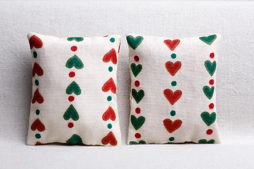 Two white pillows on the sofa with little hearts
