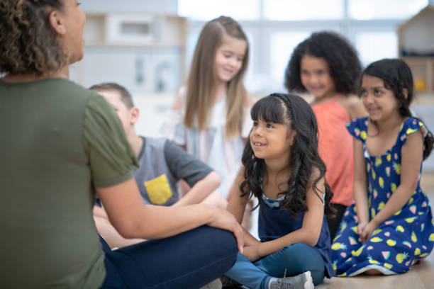 istock Group of multi ethnic children sitting on the floor in class 1295705083